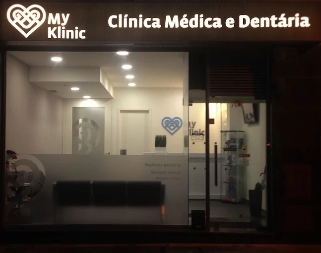 Fachada iluminada da My Klinic à noite